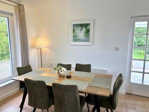 a dining room with a wooden table and chairs at Sandy Gardens House, Lettergesh Beach in Gowlaun