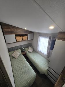 a small bedroom with two beds and a window at Barmouthbay209 in Barmouth