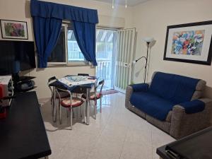 a living room with a blue couch and a table at Blue Coast Sicily in Fondachello +15 photos