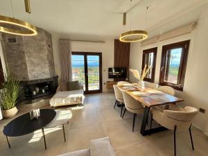 a living room with a table and chairs and a couch at Pelion PNOES Luxury Seaview Villa with priv Garden in Káto Lekhónia +37 photos