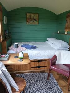 a bedroom with a bed and a desk and a chair at Lucker mill shepherds huts in Lucker
