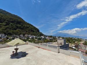 a patio with a table and an umbrella on a roof at Casa Hormiga in Panajachel +16 photos