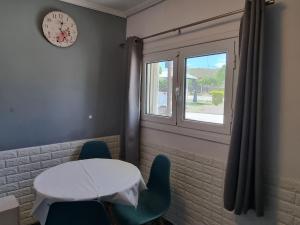 a room with a table and chairs and a clock at Isthmus Cuddly Nest in Isthmia