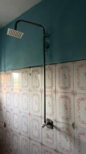 a bathroom with a pipe attached to a tiled wall at Best White House Hotel in Umunede