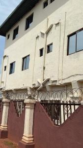 a building with a balcony on the side of it at Best White House Hotel in Umunede