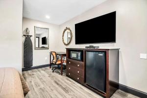 a bedroom with a flat screen tv on a wall at Best Way Inn in Middlefield
