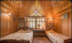 a bedroom with two beds and a window at The Martin's Houseboat in Srinagar +6 photos