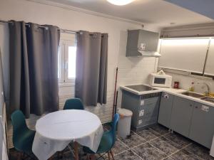 a small kitchen with a table and chairs and a microwave at Isthmus Cuddly Nest in Isthmia