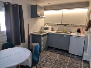 a small kitchen with a table and a microwave at Isthmus Cuddly Nest in Isthmia