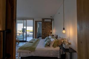 a bedroom with a bed and a brick wall at Casa Reserva jacuzzi Climatizado, Diseño y Naturaleza en Chacras de Coria in Ciudad Lujan de Cuyo