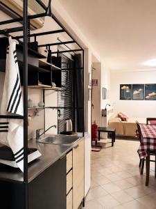 a kitchen with a sink and a living room at Civico 3 - Alloggio Turistico in Fiano Romano