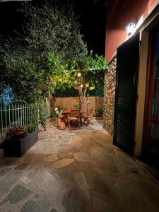 a patio at night with a table and a fence at Crueza de ma in Bonassola +13 photos