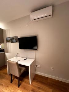 a room with a white desk and a air conditioner on a wall at Serenity De Lluxe in Kavač