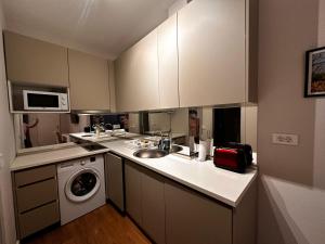 a kitchen with a sink and a washing machine at Serenity De Lluxe in Kavač