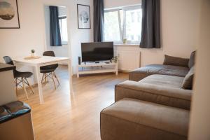 a living room with a couch and a table and a tv at Wilten 1 in Innsbruck +6 photos