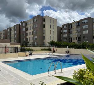 an empty swimming pool with buildings in the background at Apartamento central Moderno de lujo y con piscina in Villavicencio