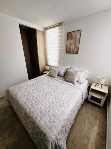a bedroom with a large bed and a window at Apartamento central Moderno de lujo y con piscina in Villavicencio +27 photos