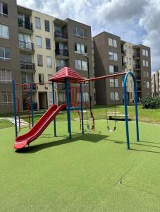a playground in front of a building with a slide at Apartamento central Moderno de lujo y con piscina in Villavicencio