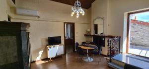 a living room with a television and a table and chairs at Appartamento La Torre in Lenno
