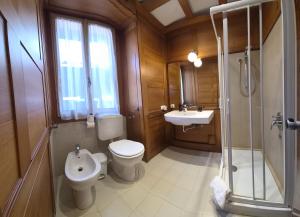 a bathroom with a toilet and a sink and a shower at Appartamento La Torre in Lenno +12 photos