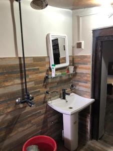 a bathroom with a white sink and a mirror at Burj Hotel Kottli Sattian in Ban