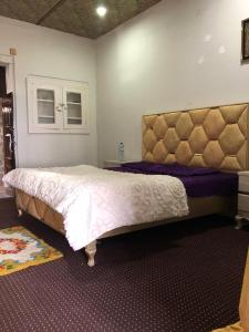 a bedroom with a large bed in a room at Burj Hotel Kottli Sattian in Ban