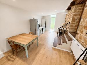 a kitchen and dining room with a table and a refrigerator at Le petit repère in Jujurieux