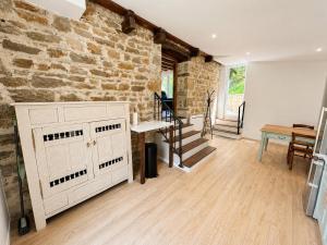 a living room with a stone wall and a table at Le petit repère in Jujurieux