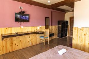 a room with a bed and a tv on a wall at Chandan Guest House in Leh