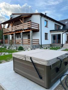 a hot tub on a patio in front of a house at Chalet pri studenom potoku in Stará Lesná
