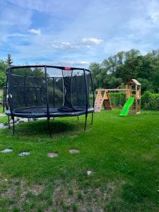 an empty trampoline in a yard with a playground at Chalet pri studenom potoku in Stará Lesná
