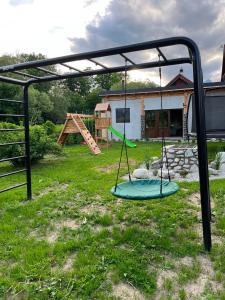 a swing set in a yard with a playground at Chalet pri studenom potoku in Stará Lesná