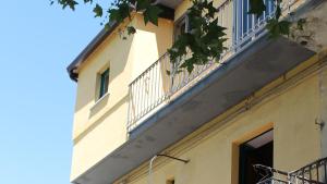 a yellow building with a balcony and a window at Casa Ela in Serra San Bruno +13 photos
