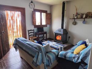 a living room with a couch and a wood stove at Alojamiento Rural El Balcón del Cielo in Trevélez +56 photos