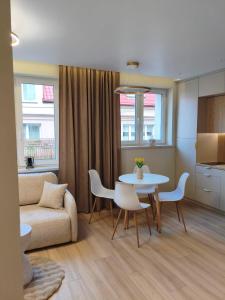 a living room with a couch and a table and chairs at Apartament Krótka in Łomża +5 photos