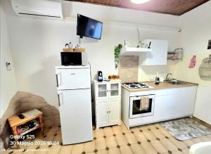 a kitchen with a white refrigerator and a stove at La Casetta in Sarroch