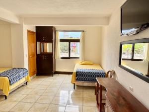 a room with two beds and a table in it at Hotel Xetawaa´l in San Pedro La Laguna