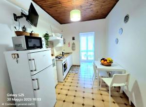 a kitchen with a white refrigerator and a table at La Casetta in Sarroch +2 photos