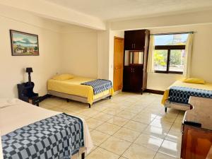 a bedroom with two beds and a window at Hotel Xetawaa´l in San Pedro La Laguna