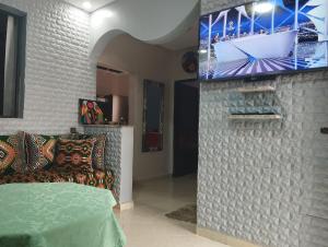 a living room with a couch and a tv on a wall at Oualidia in Oualidia