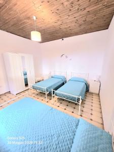 two beds in a room with wooden ceilings at La Casetta in Sarroch
