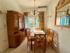 a dining room with a table and chairs and a mirror at Villa cleopatra in Mezraya