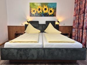 two beds in a bedroom with a painting on the wall at Hotel Garni Hutter in Unterburg am Klopeiner See