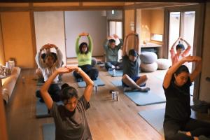 a group of people in a yoga class at 囲み宿 こわね in Tonosho