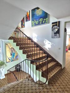 a staircase in a house with paintings on the walls at Hotel Garni Hutter in Unterburg am Klopeiner See