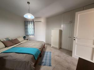 a small bedroom with a bed and a refrigerator at Cozy Aegean Escape in Skopelos Town +11 photos
