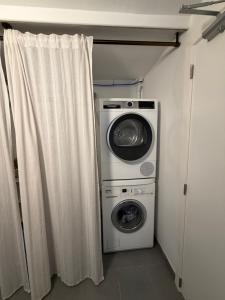 a laundry room with a washing machine and a washer at Cosy Studio naast station vlak bij Brussel in Hoeilaart
