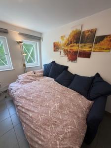 a bedroom with a large bed and some pictures on the wall at Cosy Studio naast station vlak bij Brussel in Hoeilaart