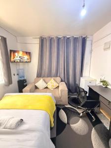 a bedroom with a bed and a couch and a desk at Ruiru Cozy stays in Ruiru