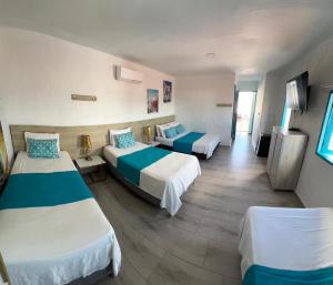 a hotel room with two beds and a television at Hotel Aldea Plaza in Doradal